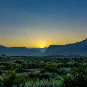 Preview wallpaper sunset, mountains, grass, distance