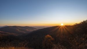 Preview wallpaper sunset, mountains, sun, rays, dusk