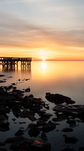 Preview wallpaper sunset, pier, horizon, stones, sea