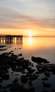 Preview wallpaper sunset, pier, horizon, stones, sea