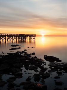 Preview wallpaper sunset, pier, horizon, stones, sea