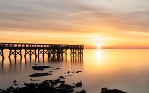 Preview wallpaper sunset, pier, horizon, stones, sea