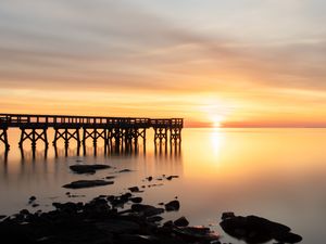Preview wallpaper sunset, pier, horizon, stones, sea