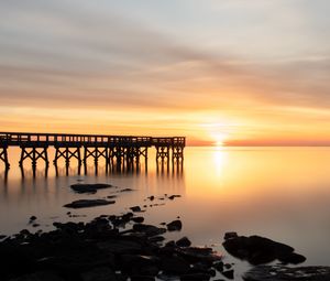 Preview wallpaper sunset, pier, horizon, stones, sea