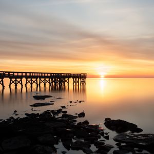 Preview wallpaper sunset, pier, horizon, stones, sea