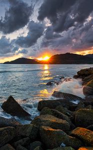 Preview wallpaper sunset, rays, coast, sea, stones