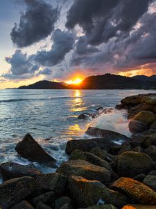 Preview wallpaper sunset, rays, coast, sea, stones