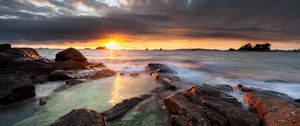 Preview wallpaper sunset, rays, stones, sea, rocks