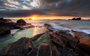 Preview wallpaper sunset, rays, stones, sea, rocks