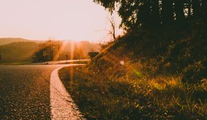 Preview wallpaper sunset, road, forest, grass, glare