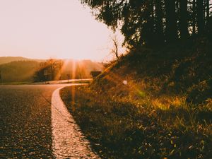 Preview wallpaper sunset, road, forest, grass, glare