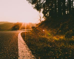 Preview wallpaper sunset, road, forest, grass, glare