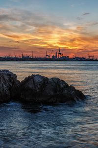 Preview wallpaper sunset, rocks, blocks, sea