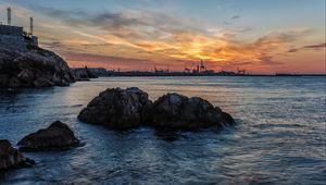 Preview wallpaper sunset, rocks, blocks, sea