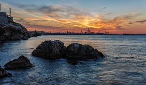 Preview wallpaper sunset, rocks, blocks, sea