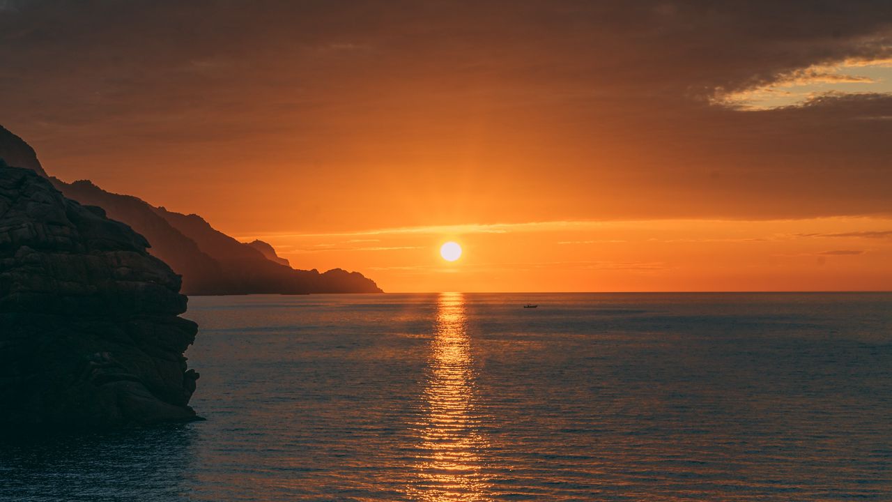 Wallpaper sunset, rocks, glare, sea, horizon
