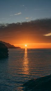 Preview wallpaper sunset, rocks, glare, sea, horizon