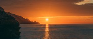 Preview wallpaper sunset, rocks, glare, sea, horizon