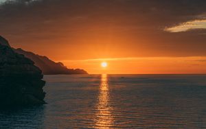 Preview wallpaper sunset, rocks, glare, sea, horizon