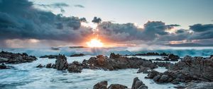 Preview wallpaper sunset, rocks, sea, stones, clouds