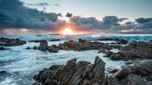 Preview wallpaper sunset, rocks, sea, stones, clouds