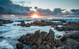 Preview wallpaper sunset, rocks, sea, stones, clouds