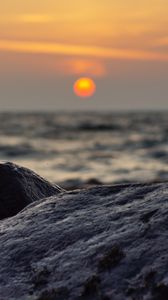 Preview wallpaper sunset, rocks, stones, sea, blur