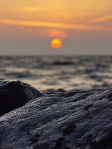 Preview wallpaper sunset, rocks, stones, sea, blur