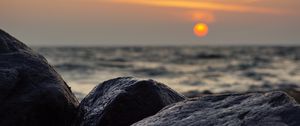 Preview wallpaper sunset, rocks, stones, sea, blur