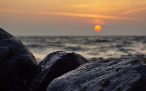 Preview wallpaper sunset, rocks, stones, sea, blur