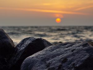 Preview wallpaper sunset, rocks, stones, sea, blur