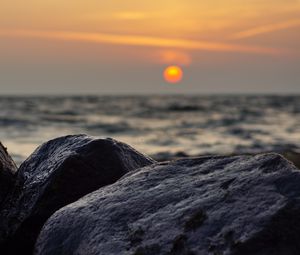 Preview wallpaper sunset, rocks, stones, sea, blur