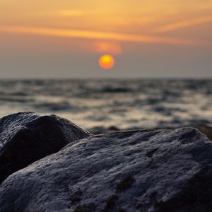 Preview wallpaper sunset, rocks, stones, sea, blur