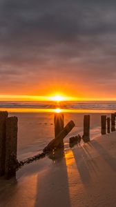 Preview wallpaper sunset, sea, beach, pillars, sand