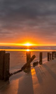 Preview wallpaper sunset, sea, beach, pillars, sand