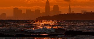 Preview wallpaper sunset, sea, city, dark, waves, horizon