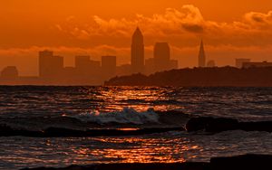 Preview wallpaper sunset, sea, city, dark, waves, horizon