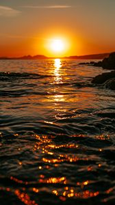 Preview wallpaper sunset, sea, glare, rocks, sky