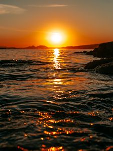 Preview wallpaper sunset, sea, glare, rocks, sky