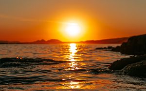 Preview wallpaper sunset, sea, glare, rocks, sky