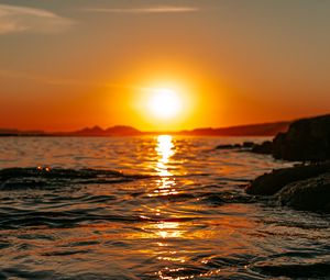 Preview wallpaper sunset, sea, glare, rocks, sky