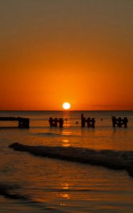 Preview wallpaper sunset, sea, pier, pilings