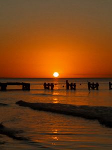 Preview wallpaper sunset, sea, pier, pilings