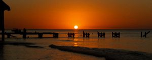 Preview wallpaper sunset, sea, pier, pilings