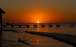 Preview wallpaper sunset, sea, pier, pilings