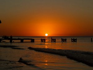 Preview wallpaper sunset, sea, pier, pilings