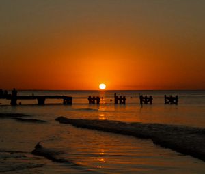 Preview wallpaper sunset, sea, pier, pilings