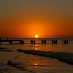 Preview wallpaper sunset, sea, pier, pilings