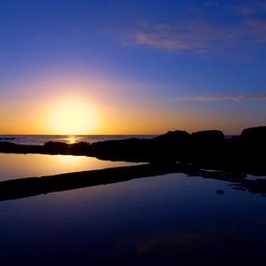 Preview wallpaper sunset, sea, rocks, outlines, silence, horizon