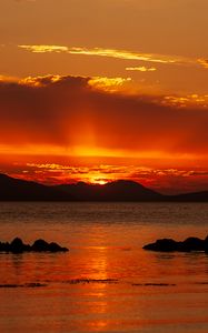 Preview wallpaper sunset, sea, stones, hills, sky